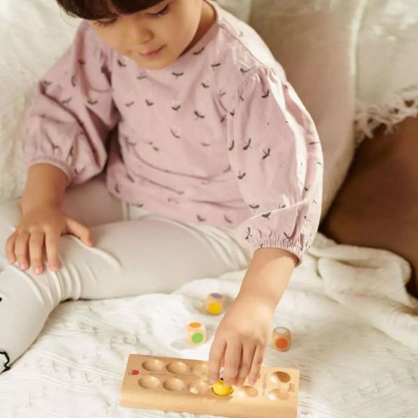 Una niña pequeña sentada en una cama jugando con un juguete, un rompecabezas de Kim Tschang Yeul, destacado en dribble, dau-al-set, patrón repetitivo, foto de stock, ganador del concurso.