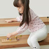 Una niña pequeña jugando con un juguete de madera, una foto de stock de Lü Ji, destacada en dribble, lyco art, patrón repetitivo, fondo blanco, foto de stock.