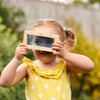 Una niña pequeña sosteniendo un marco de foto en su cara, una foto de stock por Elinor Proby Adams, ganador del concurso de Shutterstock, nueva objetividad, profundidad de campo poco profunda, fotografía de stock, atribución de Creative Commons.