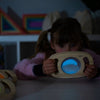 Load image into Gallery viewer, Una pequeña niña sosteniendo un juguete de madera delante de su rostro, una holografía de Évariste Vital Luminais, que se muestra en Dribble, arte interactivo, bioluminiscencia, Adafruit, luminiscencia.