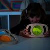Una jovencita está jugando con un juguete de madera, un holograma de Paul Feeley, presentado en dribble, arte interactivo, bioluminiscencia, luz de borde y iluminación volumétrica.