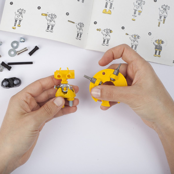 Una pareja de manos sosteniendo herramientas de construcción amarillas, un rompecabezas de Rube Goldberg, presentado en dribble, ensamblaje, behance hd, hecho de goma, atribución Creative Commons.