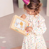Una niña pequeña está sosteniendo un libro de imágenes, una ilustración de cuento de hadas de Annabel Kidston, ganadora del concurso de Pinterest, arte ingenuo, patrón repetitivo, pixel perfecto, ilustración de cuento de hadas.