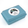 Una caja para almuerzo azul con una pegatinas de controlador de juego en ella, un render 3D por Lucia Peka, ganadora del concurso de Pixabay, figurativismo, Adafruit, #myportfolio, arte de juego 2D.