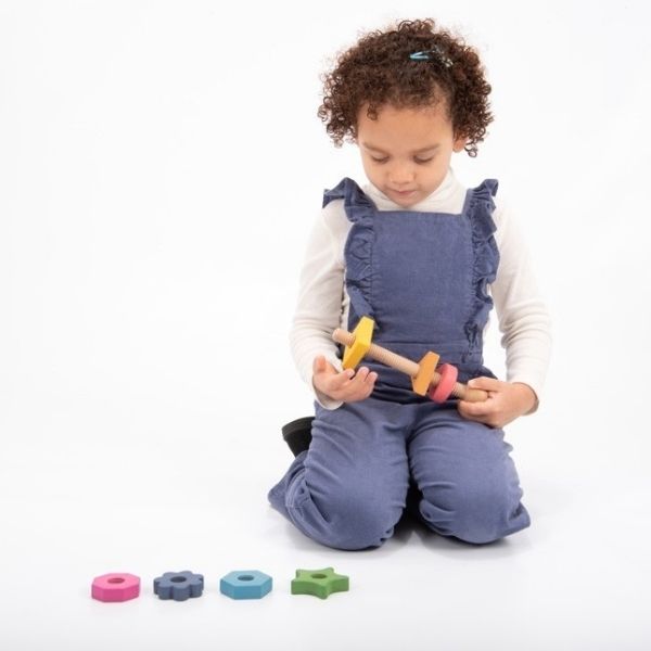 Una niña pequeña sentada en el suelo jugando con juguetes, una foto de archivo de Rube Goldberg, ganadora del concurso de Shutterstock, ensamblaje, foto de archivo, fotografía de estudio, Adafruit.