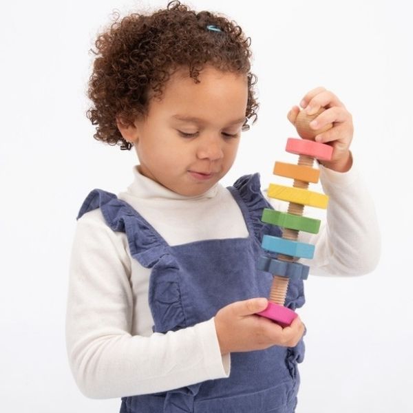 Una niña pequeña jugando con un juguete de bloque de madera, una escultura abstracta por Keos Masons, ganador del concurso de Shutterstock, arte cinético, fotografía de estudio, foto de stock, stockphoto.