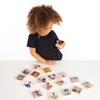 Una pequeña niña sentada en una mesa mirando fotos, un rompecabezas de Ulrika Pasch, ganador del concurso de Pinterest, ensamblaje, fotografía de estudio, instax, foto de stock.