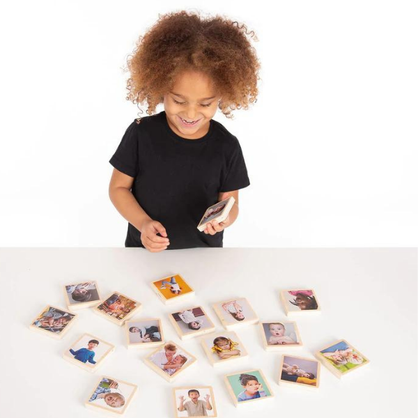 Una niña pequeña de pie frente a una mesa con fotos sobre ella, un rompecabezas de Harriet Zeitlin, ganador del concurso de Pinterest, ensamblaje, instax, fotografía de estudio, foto de stock.