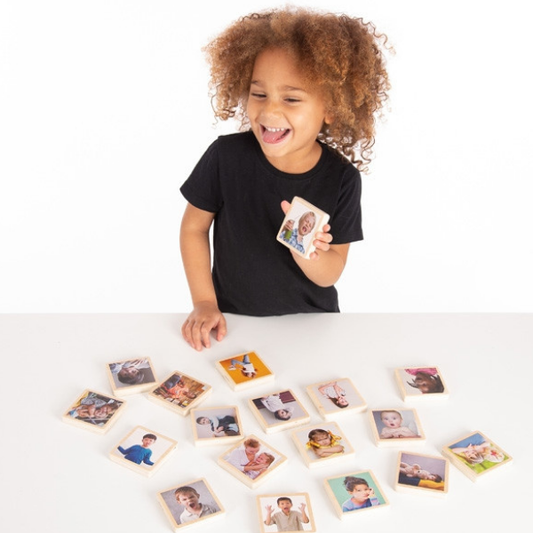 Una pequeña niña está jugando con algunas fotos, un rompecabezas de Beatrice Huntington, ganadora del concurso de Pinterest, assemblage, foto de stock, stockphoto, fotografía en estudio.