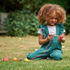 Una pequeña niña sentada en la hierba jugando con un juguete, un bordado de punto de cruz de Annabel Kidston, ganadora de un concurso de Pinterest, movimiento de artes y oficios, foto de stock, dibujo de un niño, foto de stock.