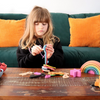 Una pequeña niña jugando con juguetes sobre una mesa, una escultura abstracta de Ottilie Maclaren Wallace, destacada en dribble, movimiento de artes y artesanías, adafruit, hechas de goma, hechas de cartón.