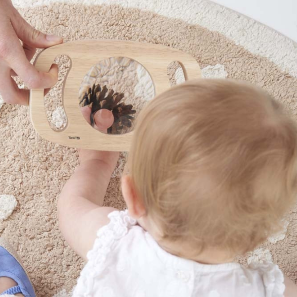 Un bebé sentado en el suelo jugando con un juguete, un rompecabezas de Méret Oppenheim, presentado en dribble, arte cinético, ortogonal, stockphoto, composición dinámica.