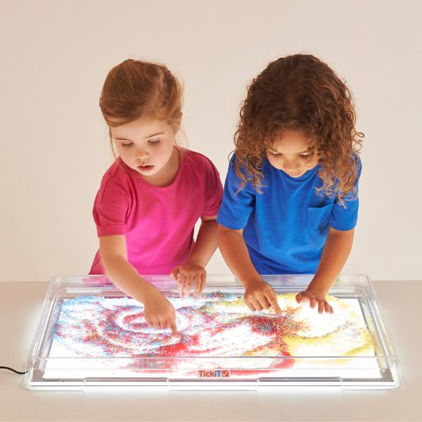 Dos jóvenes niñas están jugando con una caja de luz, gráficos de computadora por Irene y Laurette Patten, destacado en dribble, arte interactivo, tecnología futura, bioluminiscencia, luminiscencia.