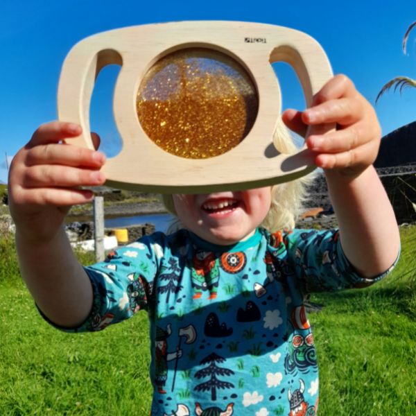 Un pequeño niño sosteniendo un juguete de madera, un rompecabezas de Esther Blaikie MacKinnon, ganador del concurso de Instagram, arte ecológico hecho de insectos, luz de borde, patrón repetitivo.