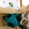 Una bola verde de lana en una caja marrón, una escultura abstracta de Louise Abbéma, ganador del concurso de Pinterest, ensamblaje, ganador del concurso, tesseract, hecho de goma.