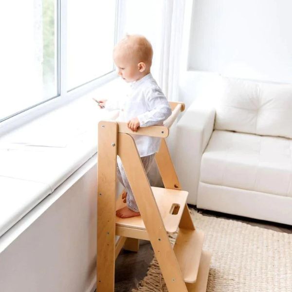 Una bebé de pie sobre un taburete de madera, una foto de stock de Ottilie Maclaren Wallace, tendencia en Pinterest, arte Lyco, minimalista, fondo blanco, ortogonal.