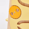 Un par de aretes amarillos sentados en la parte superior de una mesa de madera, una escultura abstracta de Puru, presentada en dribble, arte cinético, behance hd, profundidad de campo, profundidad de campo poco profunda.