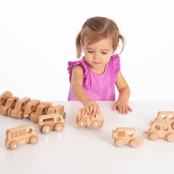Una niña pequeña jugando con juguetes de madera en una mesa, una foto de stock de Toyen, destacada en CG Society, Lyco Art, profundidad de campo, patrón repetitivo, fotografía de estudio.