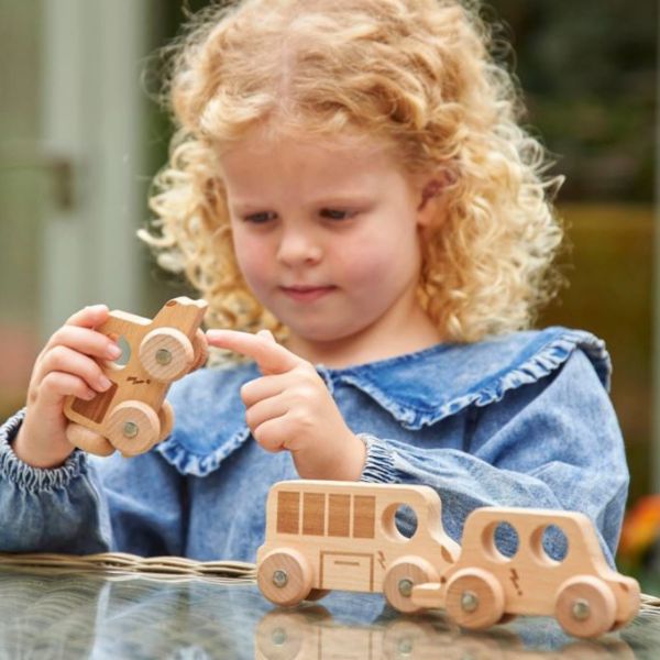 Una niña pequeña jugando con juguetes de madera en una mesa, un rompecabezas de Louisa Puller, destacado en cg society, movimiento de artesanía, hecho de cartón, patrón repetitivo, profundidad de campo.