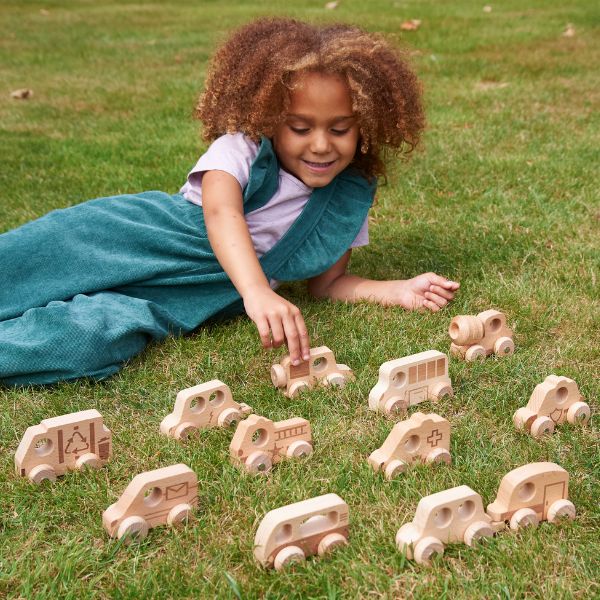 Una niña pequeña jugando con juguetes de madera en el césped, un rompecabezas de Annabel Kidston, destacado en dribble, movimiento de artesanías, profundidad de campo, patrón repetitivo, arte de juego en 2D.