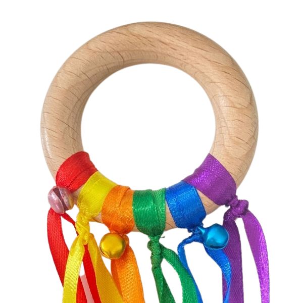 Un juguete de madera con una cinta de color arcoíris alrededor, una escultura abstracta de Penny Patricia Poppycock, ganadora del concurso de reddit, mingei, hecho de cuentas y hilo, ganadora del concurso de Adafruit.