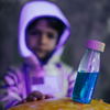 Laden Sie das Bild in den Galerie-Viewer, Un joven sosteniendo una botella de líquido azul, un holograma de Puru, tendencia en Unsplash, arte espacial, foto tomada con Ektachrome, bioluminiscencia, destello de lente anamórfica.