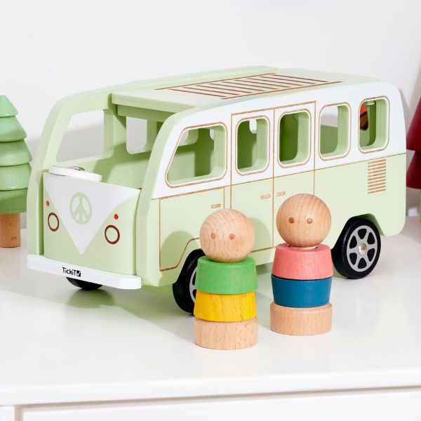 Un autobús de juguete verde con dos figuras de madera al lado, un rompecabezas de Annabel Kidston, destacado en dribble, arte ingenuo, hecho de cartón, diorama, caprichoso.