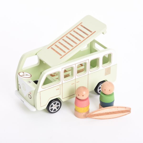 Un autobús de juguete con dos juguetes de madera delante de él, un rompecabezas de Annabel Kidston, ganador del concurso de Pinterest, movimiento de artesanía, hecho de cartón, hecho de goma, caprichoso.