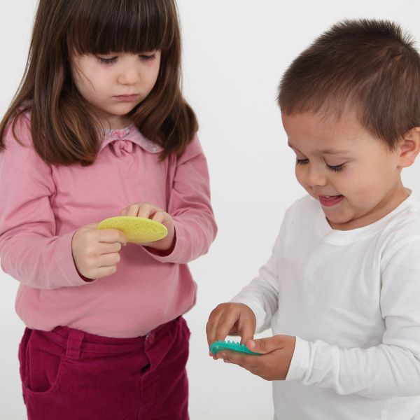 Dos niños están jugando con un cepillo de dientes y pasta de dientes, una foto de stock de Lydia Field Emmet, Shutterstock, Plasticien, Stockphoto, Stock Photo, Fotografía de estudio.