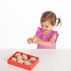 Una pequeña niña jugando con una caja de huevos, una foto de stock por Richard Doyle, Shutterstock, Los Automatistes, Foto de Stock, Foto de Stock, Atribución Creative Commons.