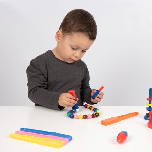 Un joven niño está jugando con juguetes en una mesa, una escultura abstracta por Rube Goldberg, presentada en CG Society, Constructivismo Modular, Stockphoto, Ortogonal, Patrón Repetitivo.