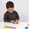 Un joven niño jugando con un juguete en una mesa, una foto de stock de Rube Goldberg, presentada en dribble, les automatistes, adafruit, patrón repetitivo, foto de stock.