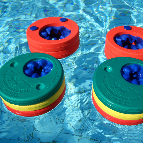 Dos frisbees flotando en una piscina de agua, una foto de stock de Toss Woollaston, ganador del concurso de shutterstock, plástico, hecho de goma, hecho de plástico, filtro Sabattier.