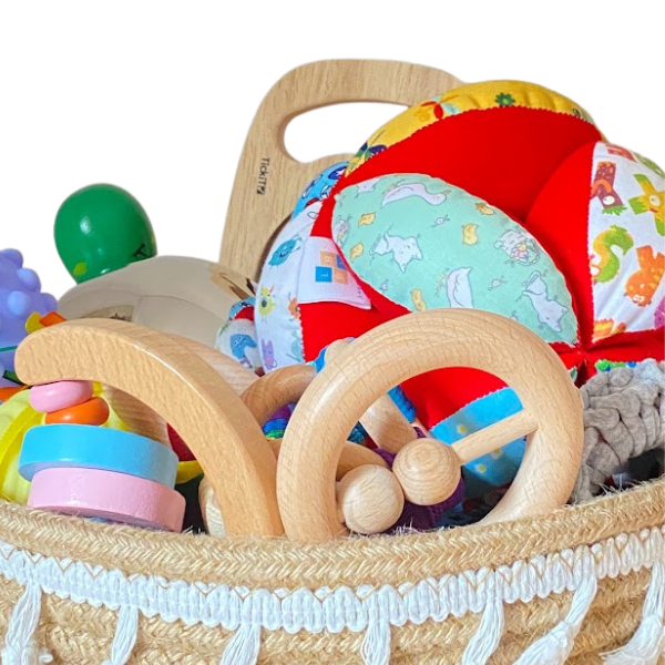 Una cesta llena de muchos juguetes encima de una mesa, una foto de stock de Irene y Laurette Patten, destacada en Pixabay, ensamblaje, foto de stock, foto de stock, desordenada.