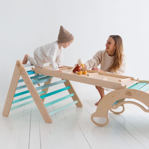 Una mujer y un niño jugando con una mesa de madera, una escultura abstracta de Ulrika Pasch, presentada en dribble, arte cinético, behance hd, composición dinámica, caprichosa.